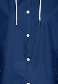 Mornarica vodoodporna jakna z gladko teksturo, ki vključuje bele zategovalne vrvice, srebrne snaps gumbe in stranske žepe.