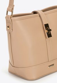 Borsa a tracolla in pelle beige con chiusura in metallo dorato, tracolla regolabile e placca con logo Wittchen sul lato anteriore inferiore.
