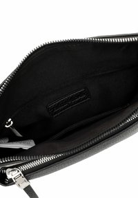 Borsa clutch in pelle nera con chiusura a zip, caratterizzata da un interno liscio e un'etichetta tessuta. La fodera è in tessuto nero, offrendo un design elegante.