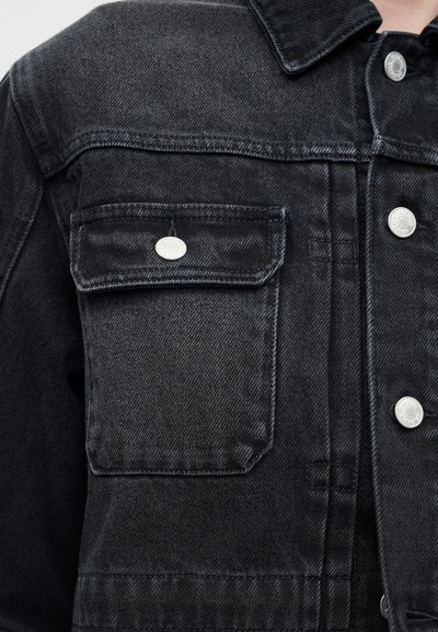 Μαύρο τζιν μπουφάν με τσέπη στο στήθος με καπάκι, ασφαλισμένη με ασημένιο κουμπί, και ασημένια κουμπιά τύπου snap κατά μήκος του εμπρός μέρους.