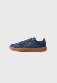 Mørkeblå sneakers laget av lær og semsket skinn, med gummisåle, rund tå og snøring med merkevareinformasjon på siden.