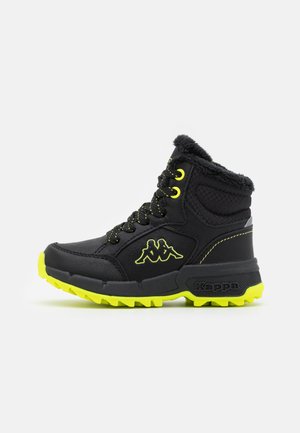 Black winter boot with neon yellow sole, laces, and logo, featuring quilted upper and fur lining around the ankle for warmth and traction.
