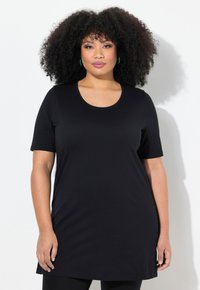 Černá tunika s krátkým rukávem a kulatým výstřihem, vyrobená z hladké tkaniny, s volným střihem, který sahá k bokům.