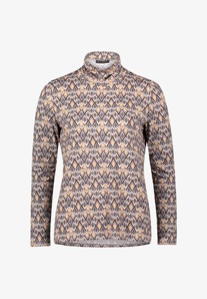 Haut à col roulé à manches longues avec un motif géométrique en losanges dans des tons beige, gris et blanc.