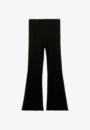 Schwarze ausgestellte Leggings aus weichem Stoff, mit einem breiten, elastischen Bund und dekorativen Nieten entlang der äußeren Nähte für zusätzliche Details.