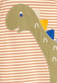 Zöld rajzfilmszerű dinoszaurusz kék szemmel és színes tüskékkel, bézs-fehér csíkos szövet háttéren.