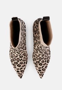 Leopardenmuster-Ankle-Boots aus einem gestrickten Material mit spitzer Zehe und elastischem Kragen, der mit einem schwarzen Akzent am Absatz versehen ist.