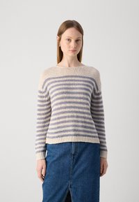 Gestreepte gebreide trui in crème en lavendel tinten, met een bootnek, geribbelde zoom en lange mouwen. Gecombineerd met een denimrok.