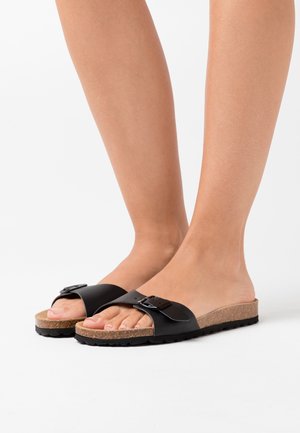 Zwarte schuursandalen met een brede band en een zilveren gesp. Kurken voetbed, gestructureerde zool, open tenen ontwerp en minimalistische stijl.