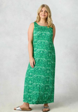 Maxime dressi vihreästä kankaasta, jossa on yksityiskohtainen valkoinen paisley- ja kukkakuosi. Olkaimeton malli, pyöreä kaula-aukko, ulottuu nilkkaan.
