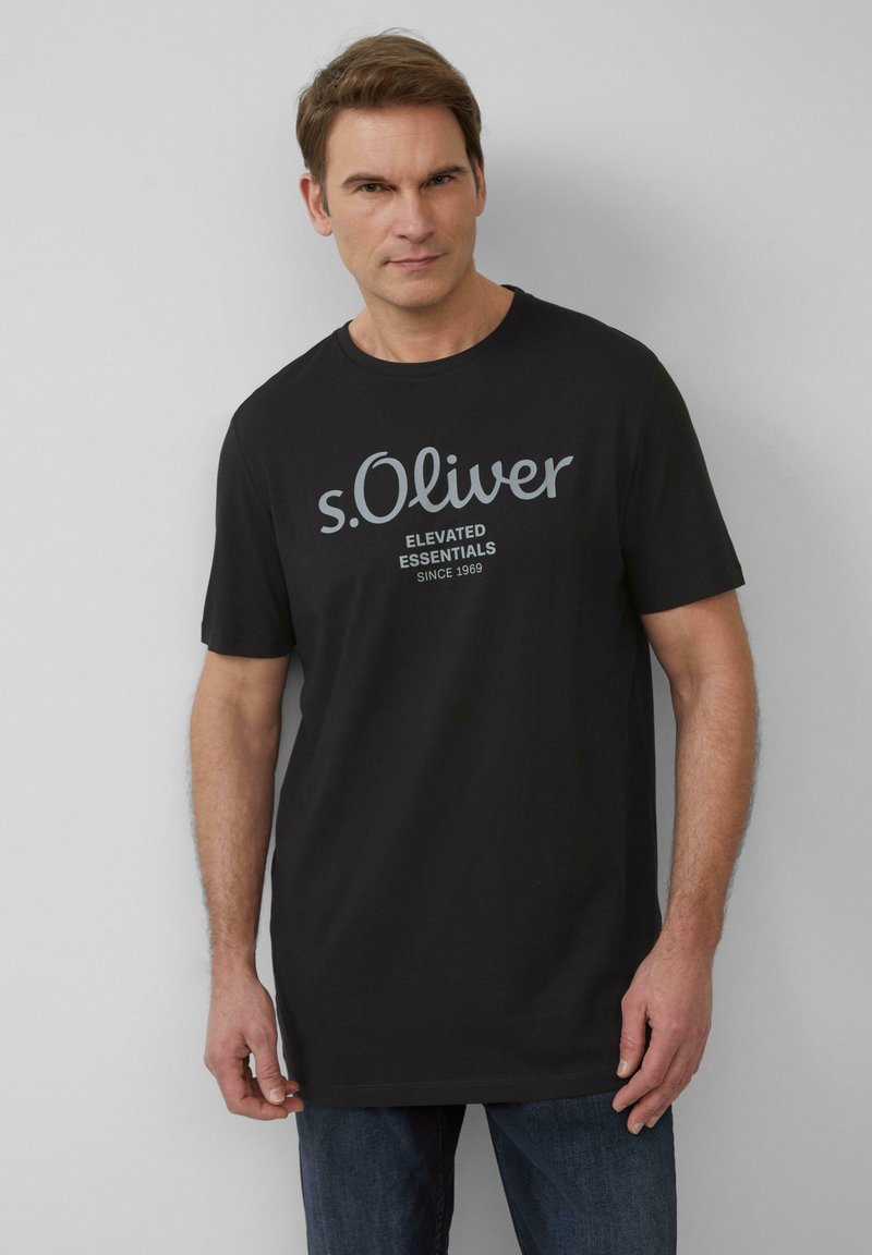 Czarna bawełniana koszulka z krótkimi rękawami z napisem "s.Oliver Elevated Essentials Since 1969" w jasnoszarym kolorze. Luźny krój.