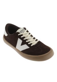 Zapatilla de ante marrón con detalles y cordones blancos, con punta redonda y suela de goma. Incluye el logotipo en la lengüeta.