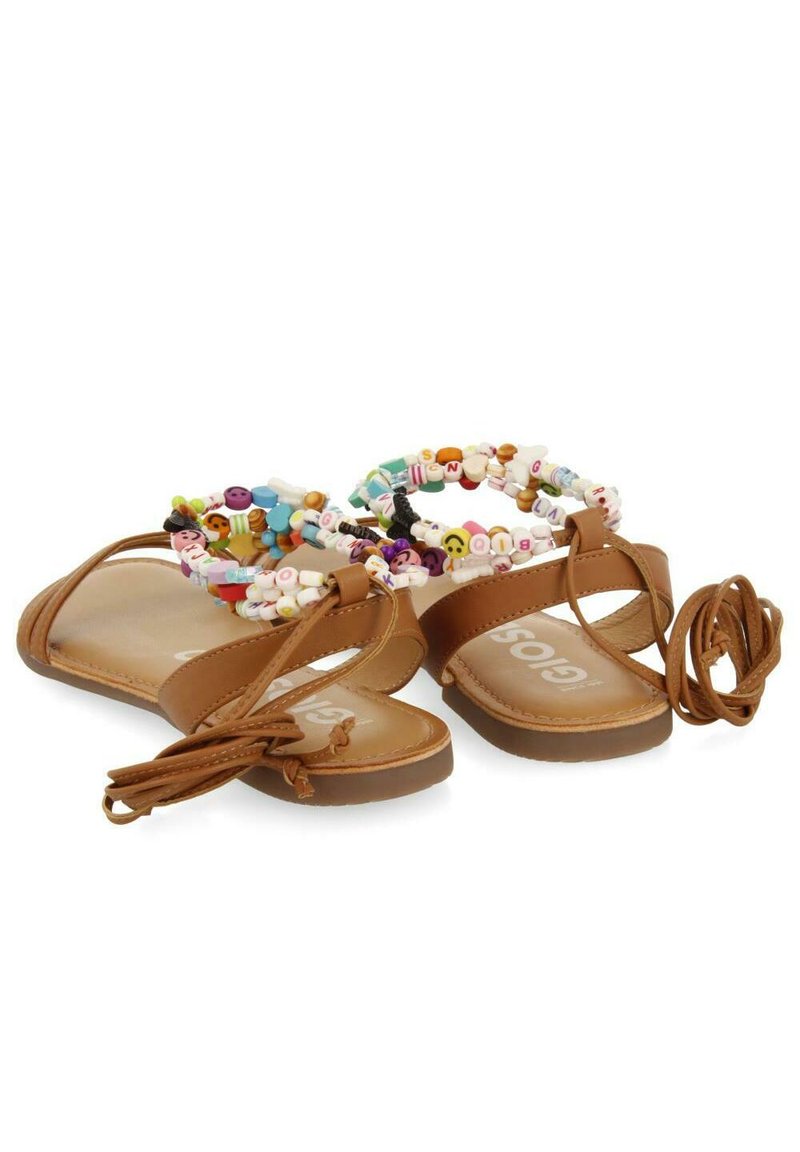 Sandalias planas marrones con suela plana y correas trenzadas. La parte superior con cuentas presenta cuentas redondas de colores y emojis. Incluye lazos para ajuste.