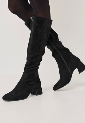 Black over-the-knee boots made of soft suede, featuring a pointed toe, block heel, and side zipper for easy wear, with a smooth texture.