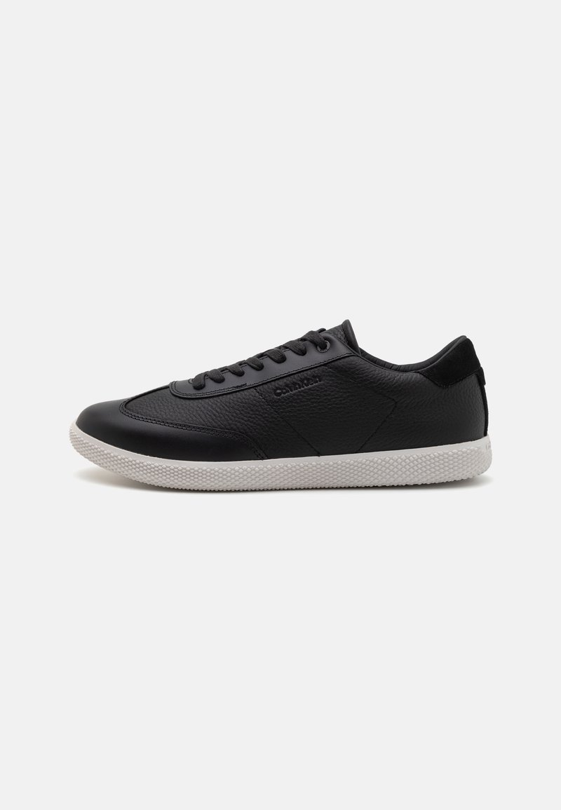 Zwarte leren sneakers met een textuurafwerking, uitgerust met een witte rubberen zool, ronde neus en platte veters. Logo aan de zijkant.