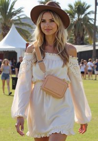 Vestito bianco scollato sulla spalla con bordo di pizzo e orlo arricciato. Abbinato a un cappello marrone e a una borsa a tracolla beige. Palme sullo sfondo.