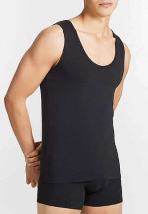 Canotta nera in morbido cotone con scollo a girocollo e design aderente. Indossata con boxer neri abbinati per un look essenziale e lineare.