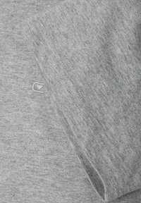 Szary bawełniany t-shirt z krótkim rękawem, subtelną melanżową fakturą i małym haftowanym logo na przodzie w pobliżu dolnego brzegu.