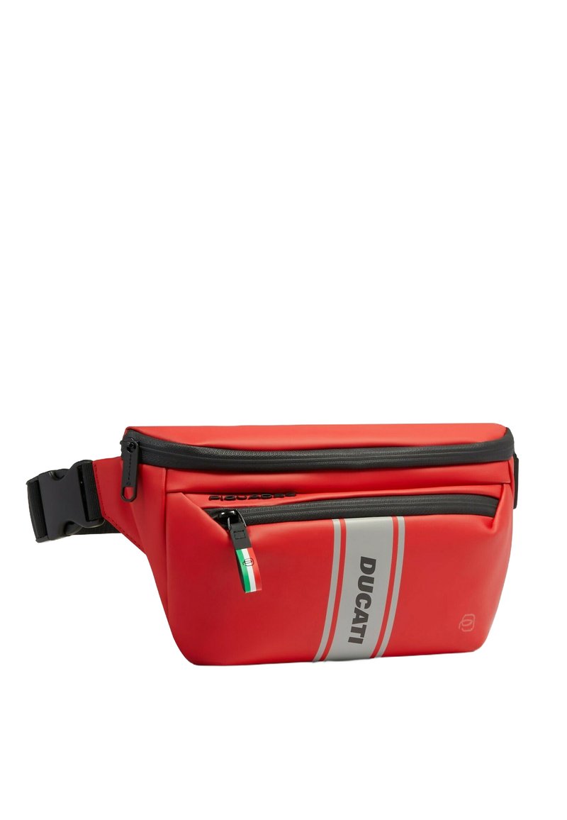 Riñonera roja con un diseño elegante, hecha de material impermeable. Cuenta con una cremallera superior, rayas plateadas y un pequeño detalle con la bandera italiana.