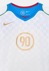 Λευκή ποδοσφαιρική φανέλα με καρό μοτίβο, μπλε διχτυωτό γιακά, χρυσό "90" σε κυκλικό σχέδιο και λογότυπο Nike σε χρυσό στο στήθος.