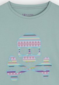 Camiseta de color verde claro con un diseño colorido de calavera y tibias cruzadas. El diseño incluye rayas y triángulos en colores pastel.
