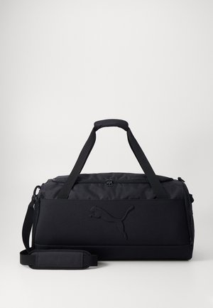 Czarna torba sportowa wykonana z trwałego materiału, z podwójnymi uchwytami, regulowanym paskiem na ramię oraz wytłoczonymi detalami logo. Gładka tekstura.