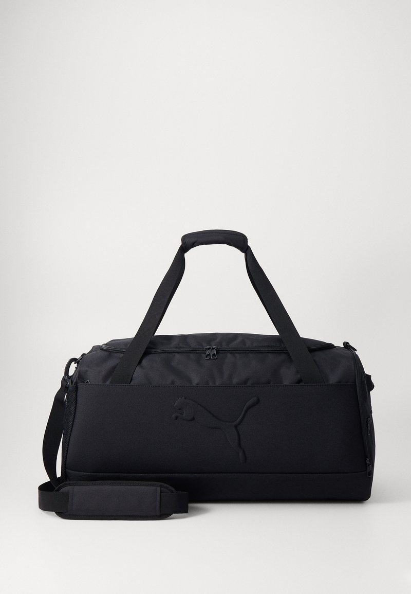 Mala de desporto preta feita de um tecido durável, com alças duplas, uma correia de ombro ajustável e detalhes de logotipo em relevo. Textura suave.