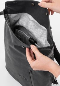 Borsa tote nera in pelle con un'esterno testurizzato, dotata di una fodera a motivo a griglia chiara e numerosi scomparti interni per una migliore organizzazione.