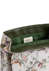 Torba z rožnatim vzorcem z mehke zunanjosti, notranjost iz zelenega usnja, gumbasta zapirala in oznaka z napisom "FABLE ENGLAND."