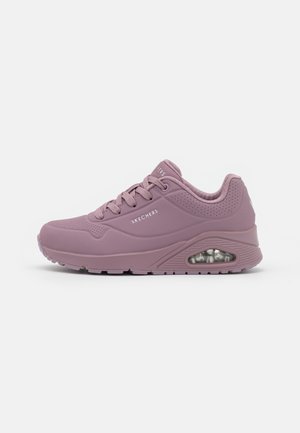 Lilla Skechers sneaker med polstret sål, synlig luftlomme, perforerede detaljer og snørelukning på ensfarvet baggrund.