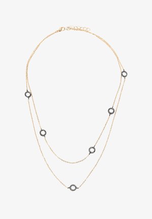 Naszyjnik warstwowy w złotym odcieniu, składający się z dwóch łańcuszków. Na całości równomiernie rozmieszczone okrągłe czarne akcenty z metalicznymi detalami.