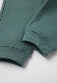 De teal kleurige sweatshirt manchetten hebben een geribbelde structuur en een zachte textuur, met een gladde afwerking en gestructureerde, afgeronde randen voor een verzorgde uitstraling.