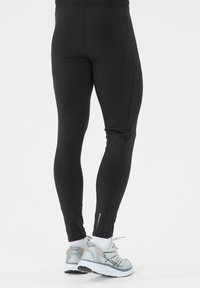 Leggings deportivos negros con una textura suave y elástica. Diseño ajustado con detalles de costura en contraste y una silueta elegante y minimalista.