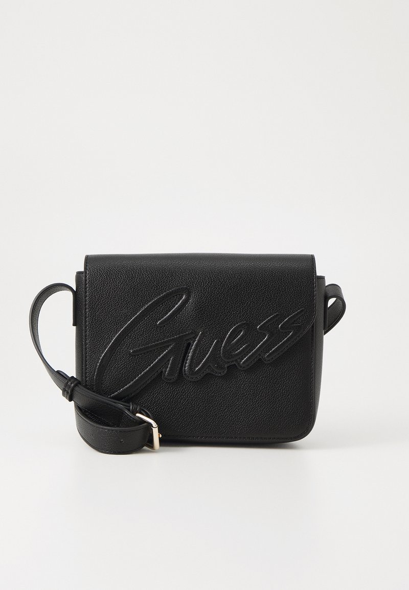Saco de ombro preto feito de couro texturizado, com um logótipo "Guess" em relevo proeminente na frente e uma alça destacável.
