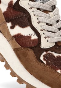 Zapatillas de vaquero en estampado marrón y blanco con detalles de ante, parte superior texturizada, punta redonda y cordones planos. Suela de goma con un diseño dentado.