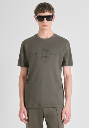 Maslinasto zelena pamučna majica s kratkim rukavima, okruglim izrezom i urezanim logotipom "ANTONY MORATO" sprijeda. Glatka tekstura.