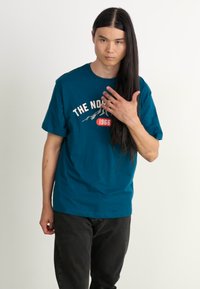 The North Face M VARSITY GRAPHIC RELAXED SS TEE - Triko s potiskem - midnight petrol