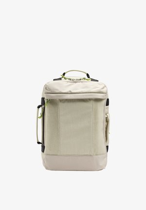 Beżowy prostokątny plecak z bocznymi panelami z siateczki, podwójnymi górnymi uchwytami, bocznym uchwytem oraz zamkami błyskawicznymi z zielonymi sznureczkami do ściągania.