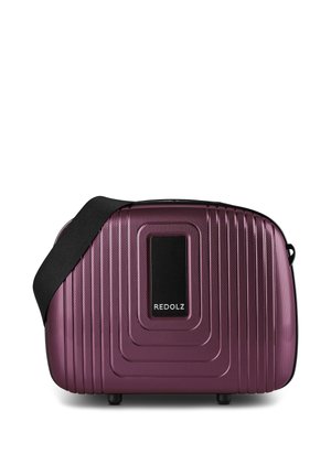 Compacte harde paarse reistas met getextureerde ribbels, zwarte riem en een zwart vierkant label met de merknaam REDOLZ.