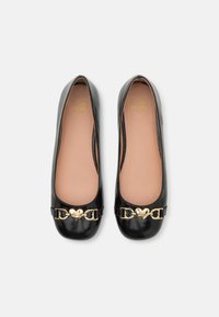 Bailarinas em verniz preto com um logótipo em forma de coração dourado e detalhe em corrente na área dos dedos; textura suave e design de bico arredondado.