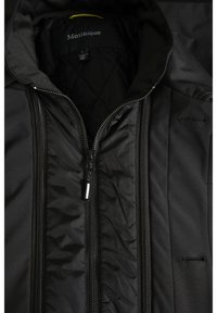 Giacca nera con zip, interno trapuntato, esterno liscio, colletto alto, doppie cerniere e logo discreto all'interno.