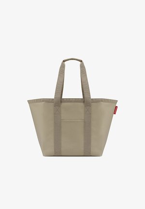 Beige tote bag with wide straps, front pocket, and a small red tag on the side, displayed against a white background.