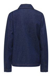 Tumesinises denimis jope klassikalise kraega, pikkade varrukatega ja nähtava õmblusega. Omab sirget lõiget ja minimaalset disaini.
