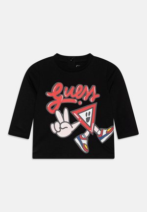 Sort langærmet trøje til tumlinger med tegneserie-“Guess”-tekst, en smilende rød trekant figur, fredstegn-hånd og farverige sneakers.
