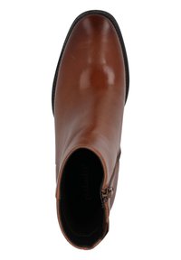 Botín de cuero marrón hasta el tobillo con una textura suave, que cuenta con una cremallera lateral y una punta redonda. Suela negra con un sutil detalle de costura.