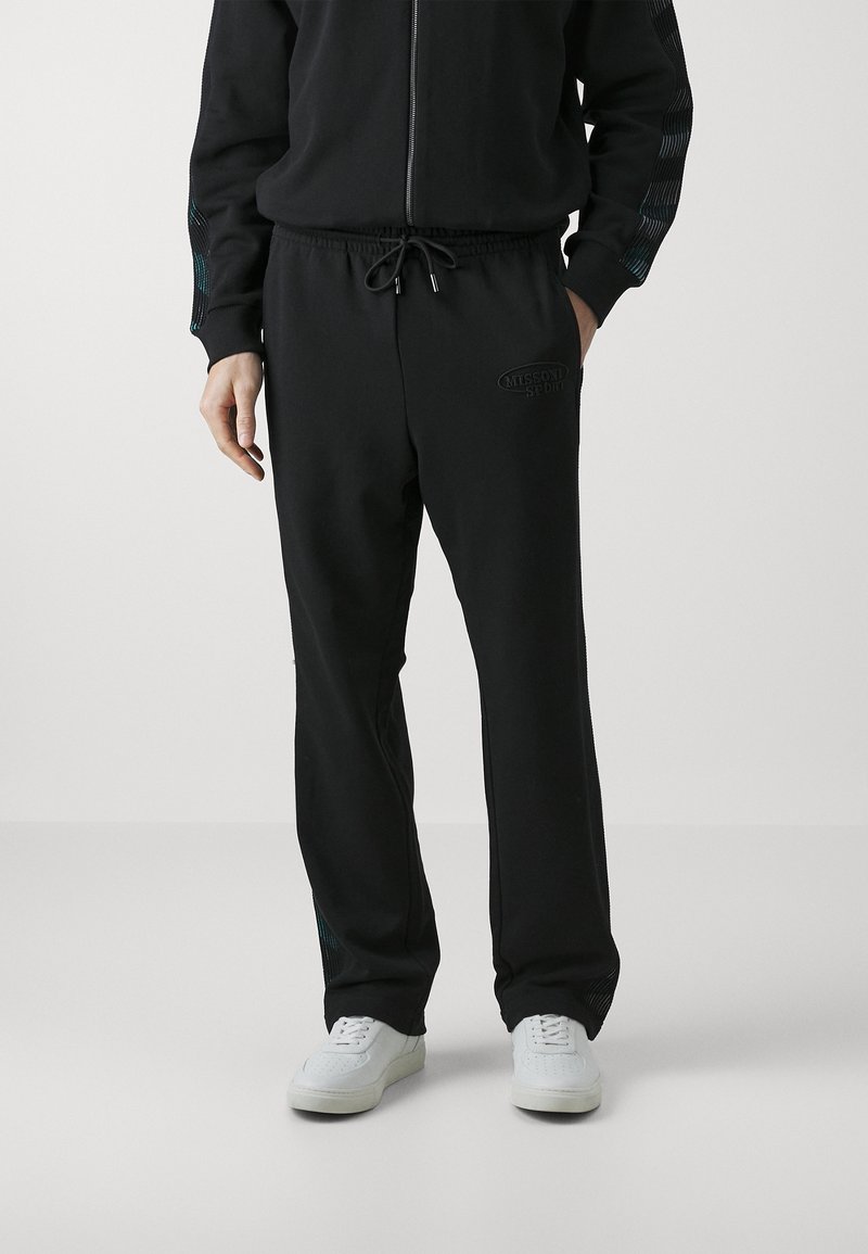 Black sweatpants with elastic waistband, drawstring, and subtle branding. Features textured side accents in blue. Material appears soft.
