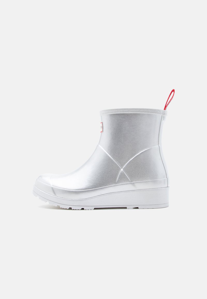 Ασημί λαστιχένια αδιάβροχη μπότα μέχρι τον αστράγαλο με λευκή σόλα και κόκκινη υφασμάτινη θηλιά στο πίσω μέρος.