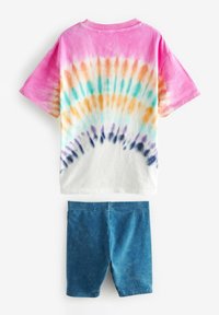 T-shirt z krótkim rękawem w tie-dye z różowymi, pomarańczowymi i niebieskimi wzorami, zestawiony z jednolitymi niebieskimi szortami z przewiewnego materiału.