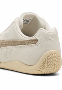 Beżowe sneakersy z zamszowej cholewki, miękkimi tekstylnymi akcentami oraz gumową podeszwą z fakturowanym bieżnikiem. Logo z tyłu.