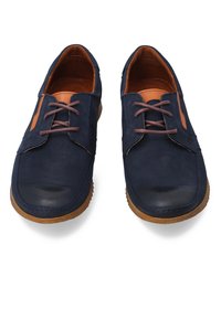 Navy modré kožené boty s hnědými akcenty, mají zaoblenou špičku, šněrování a texturovanou gumovou podešev.